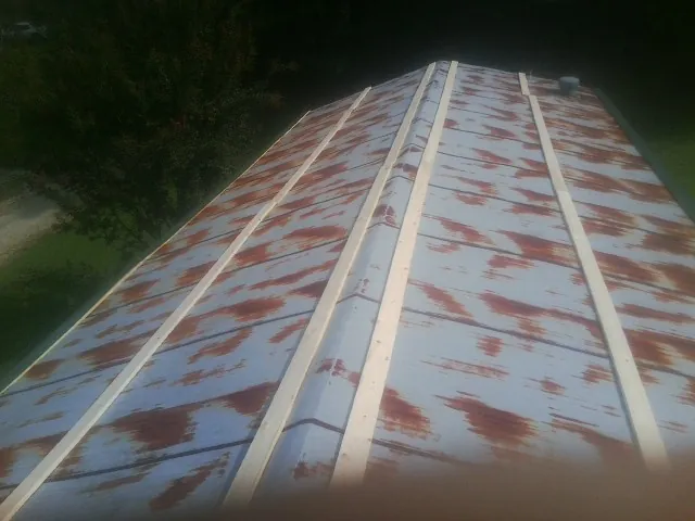 Rusted metal roof panels with new wood purlins before replacement — Storm Damage Roof Repair in Glen Burnie by Roofing Brothers