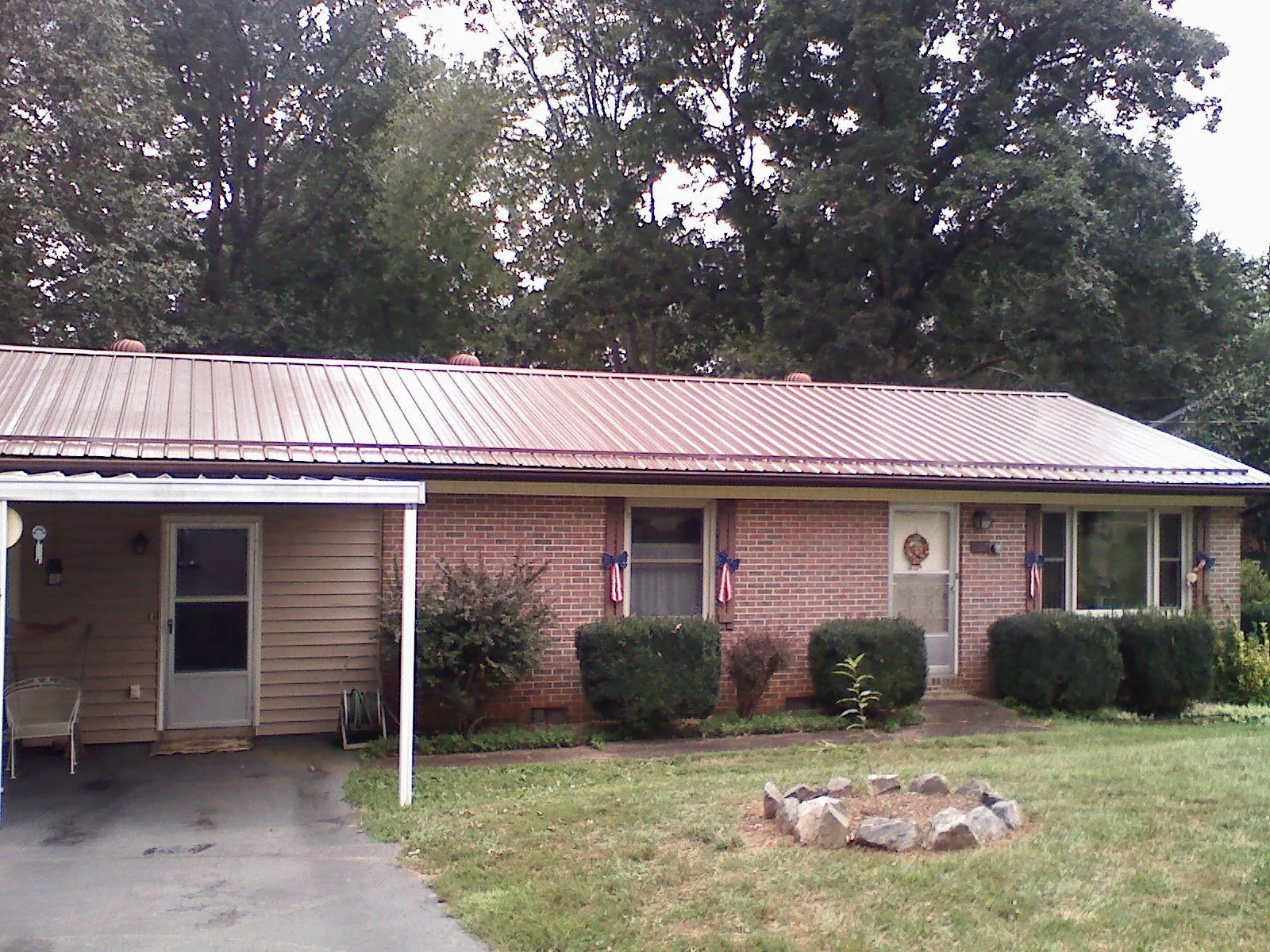 Bronze metal roof and carport on a brick ranch home — Roof Repair work by our crew in Glen Burnie