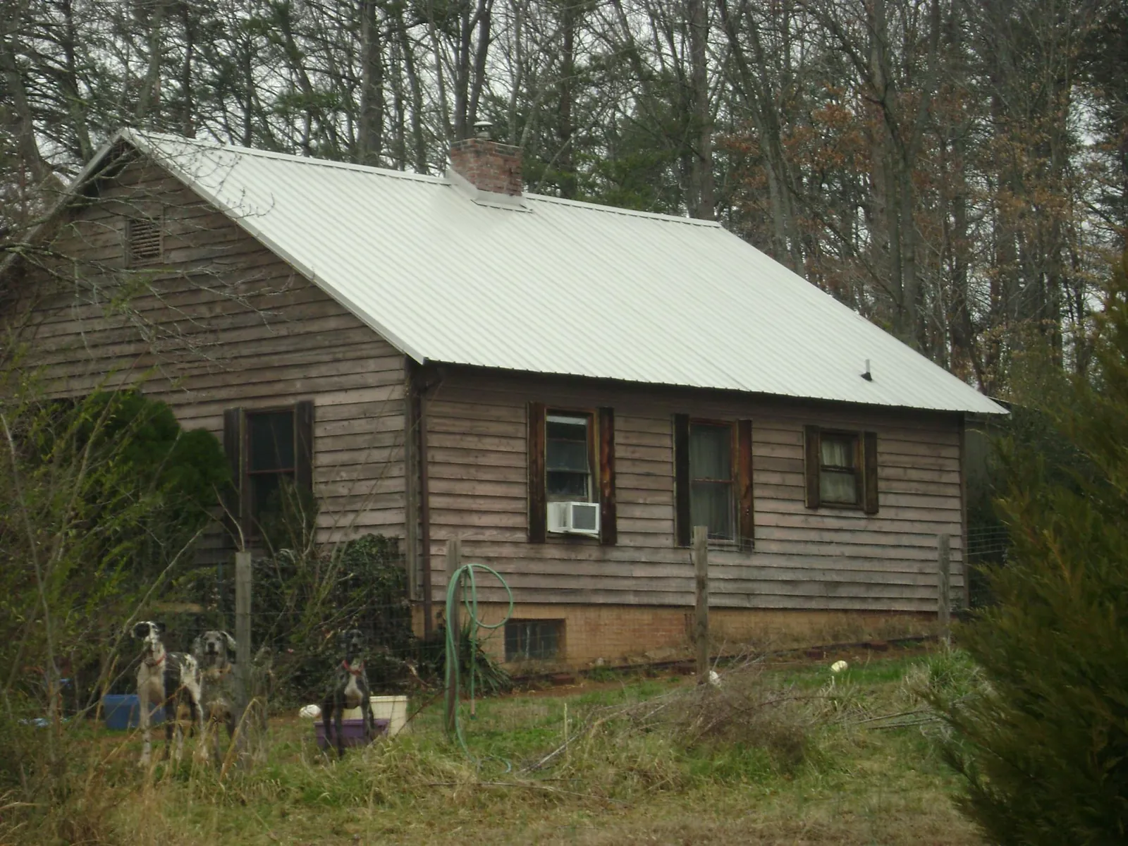 White metal roof on an old wood sided farmhouse, from a Asphalt Shingle Roof Repair job in Glen Burnie